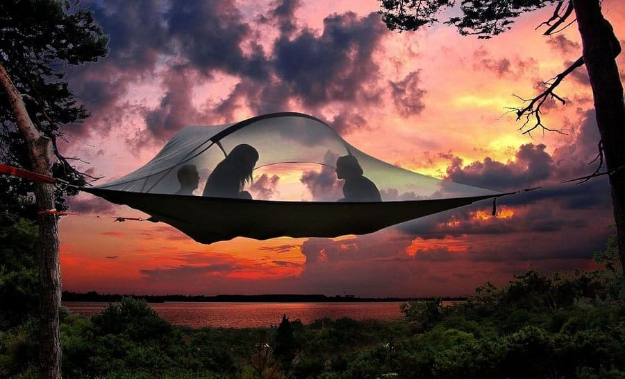 Tente suspendue Tentsile installée entre trois arbres au crépuscule